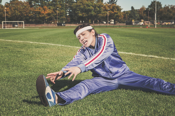 stretching,tracksuit,track and field,sports,athlete,fitness,shoes,headband,grass,field