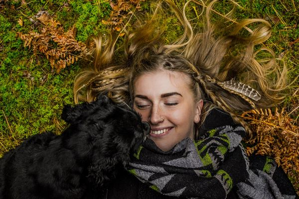 beach,dog,animal,dog,animal,pet,feather,bird,blue,woman,female,lady,hair,lying down,happy,happiness,smile,smiling,dog,scarf,feather