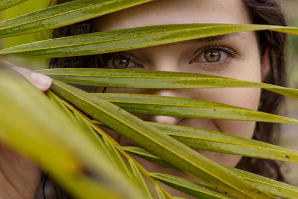 bright,close-up,environment,eyes,face,growth,outdoors,palm leaves,woman