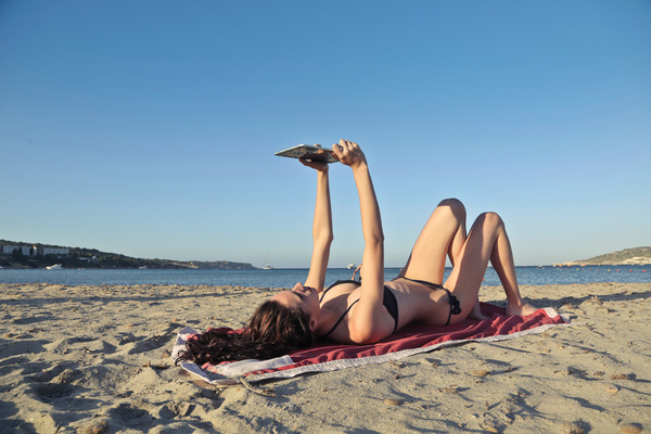 Beautiful young black skin woman in a bikini lying on the beach on