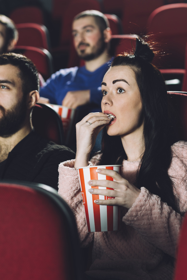 cinema,film,movie,person,popcorn,relax,eating,together,young,container,entertainment,beautiful,sitting,lifestyle,bucket,audience,joy,delicious,seat,rest