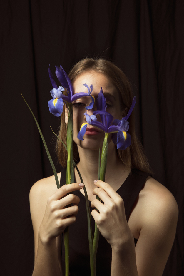 looking at camera,studio shot,pensive,adorable,thoughtful,blond,sensual,gorgeous,bloom,stem,standing,looking,calm,pretty,shot,holding,petal,season,bright,portrait,beautiful,blossom,fresh,young,dark,female,romantic,studio,lady,model,natural,plant,clothes,colorful,black,spring,face,cute,black background,hair,blue,camera,green,woman,flowers,flower,background