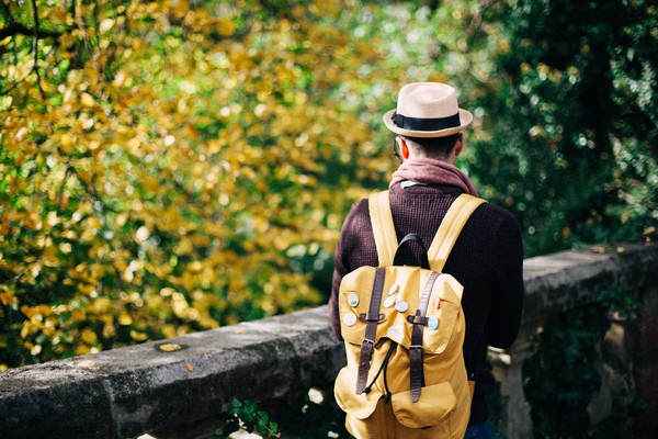 wear,tree,travel,summer,person,park,outdoors,man,leaves,hat,garden,fashion,fall,daylight,backpack,adult