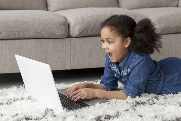 indoors,adorable,casual,curly hair,curly,positive,device,portrait,young,dancing,happy,laptop,home,hair,girl