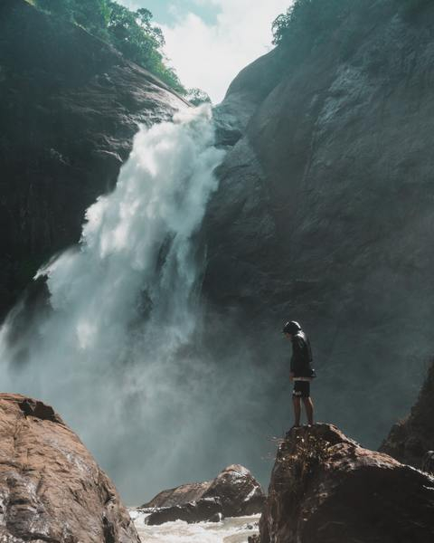 man,rocks,waterfall,male,adventure,jacket,wet,river,cliff,splash