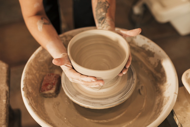 Close-up of woman's hands molding clay on wheel stock photo