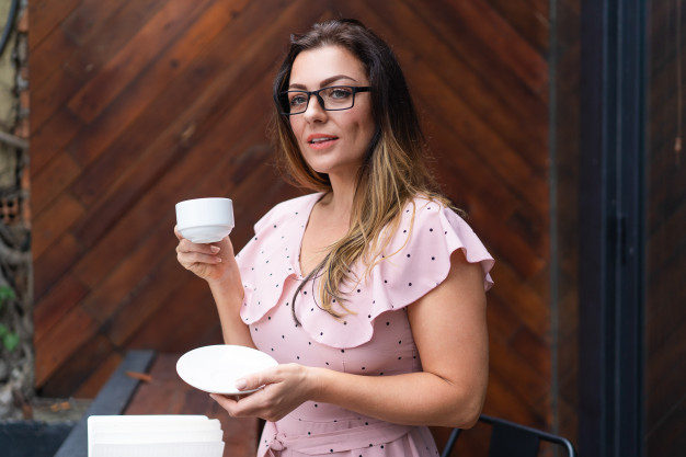 coffee,restaurant,table,shop,cafe,glasses,person,white,coffee cup,cup,dress,thinking,lady,wooden,coffee shop,wood table,female,young,smart