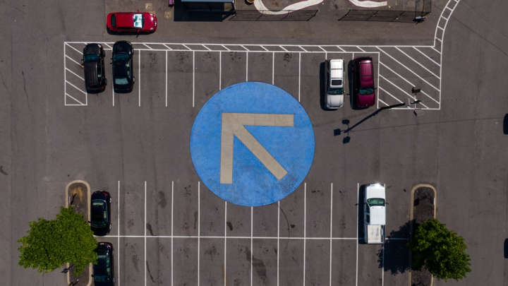 aerial,asphalt,bird&#39;s eye view,business,cars,city,daylight,drone,landscape,lanes,outdoors,parking area,parking lot,pavement,road,road sign,safety,street,traffic,travel,urban,vehicles