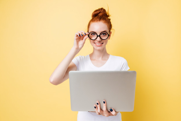 20s,caucasian,charming,redhead,posing,attractive,casual,single,looking,smiling,trendy,pretty,adult,alone,holding,ginger,eyeglasses,lovely,portrait,beautiful,gadget,young,female,body,person,happy,laptop,cute,woman,computer,people