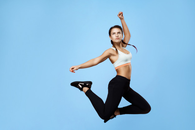 Female model in sports wear jumping in air