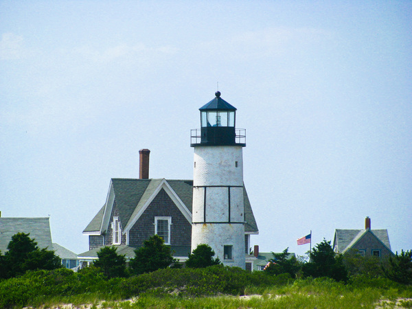 lighthouse,houses,flag,usa,united states,chimneys,sky,grass,suburb