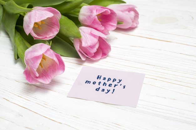overhead,closeup,arrangement,bunch,inscription,phrase,composition,surface,bloom,horizontal,tulips,carton,petal,mothers,greeting,top view,top,day,bright,beautiful,view,tulip,blossom,wooden background,fresh,word,happy mothers day,bouquet,wooden,message,natural,desk,decoration,plant,present,letter,event,holiday,colorful,text,happy,celebration,spring,cute,pink,table,green,light,paper,leaf,gift,design,floral,flower,background