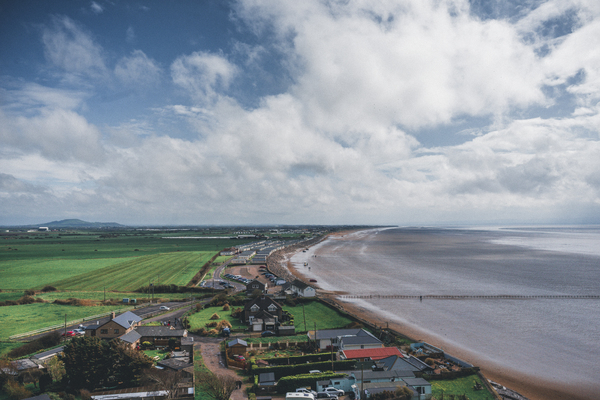 aerial shot,agriculture,beach,clouds,cropland,daylight,grass,high angle shot,houses,landscape,nature,ocean,outdoors,road,scenic,sea,seascape,seashore,sky,summer,travel,water
