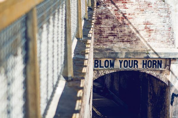 ad,iphone,phone,erin,wall,white,word,sign,neon,bloe your horn,sign,typography,brick wall,tunnel,old,house,gate,outdoor,day,sun,scene
