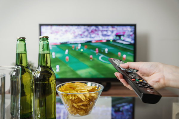 alcohol,beer,beer bottle,bottles,bowl,chips,computer,drinking glass,drinks,football,game,glass,hand,holding,home,indoors,person,remote,soccer,sport,table,technology,television,tv,watching,Free Stock Photo