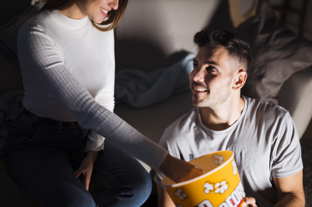 background,love,man,happy,room,couple,basket,sofa,lady,popcorn,dark background,relax,love background,romantic,female,eating,together,dark,young,snack