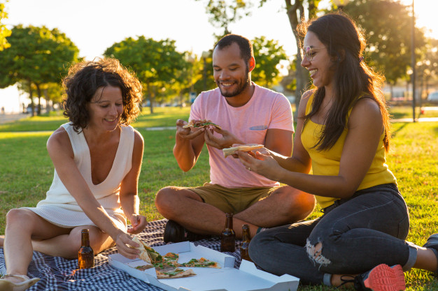 Happy Friends hanging out Together and eating Pizza · Free Stock Photo
