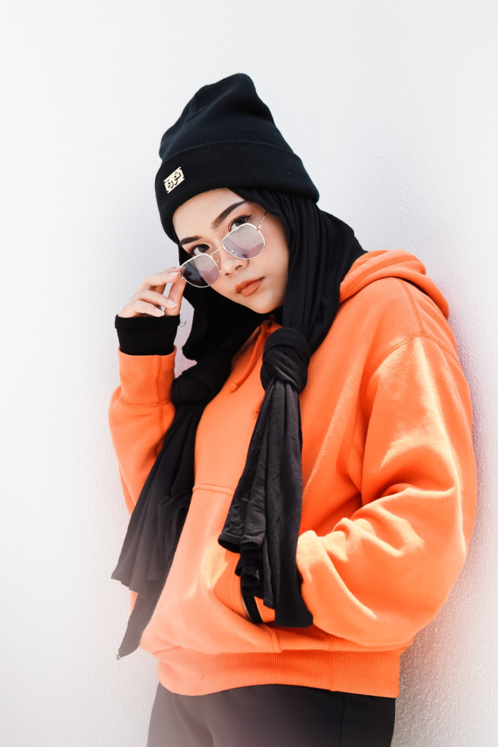 beanie,beautiful,beauty,close-up,cute,daylight,eyewear,facial expression,fashion,female,hands,leaning,model,orange,outdoors,person,photoshoot,portrait,pose,posing,scarf,street,style,sunglasses,sweater,wall,wear,woman