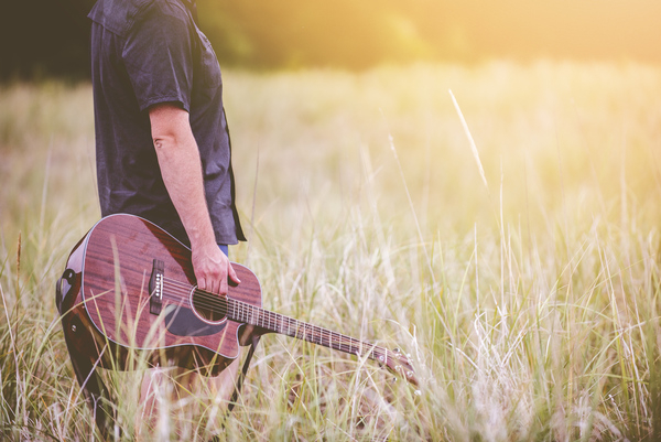 guy,man,male,people,stand,side,view,bust,hold,guitar,music,instrument,field,grass,light,leaks,still,bokeh
