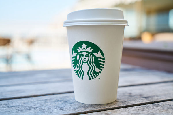 brand,business,caffeine,close-up,coffee,container,cup,disposable cup,drink,franchising,green,hot,hot drink,identity,latte,lid,outdoor,restaurant,retail,sign,starbucks,symbol,table