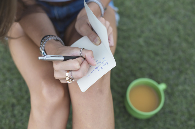 coffee,people,hand,paper,grass,text,human,note,pen,person,white,coffee cup,drink,cup,finger,writing,schedule,lady,working,message