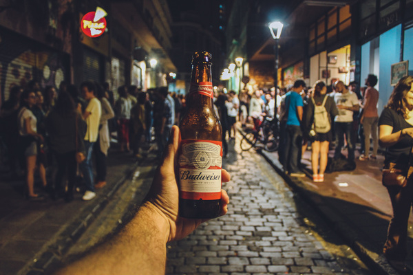 adult,bar,beer,bottle,budweiser,city,commerce,crowd,group,group together,hand,lamp post,light,market,night,outdoors,people,restaurant,road,shop,street,tourism,tourist,travel,urban,walking,wear,Free Stock Photo