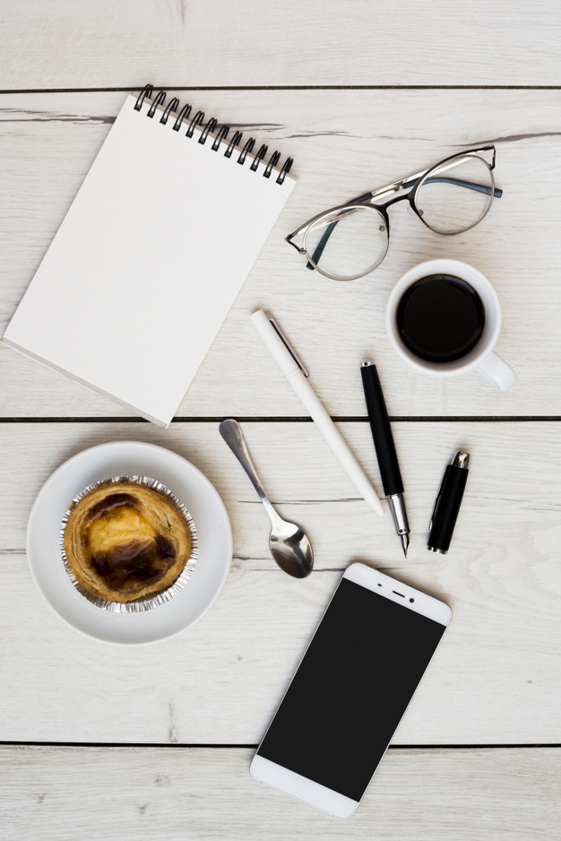 coffee,office,table,work,glasses,notebook,smartphone,pen,coffee cup,job,desk,worker,cup,spoon,morning,eating,workspace,office desk,pastry,view,top,top view,office supplies,objects,supplies,ballpoint,ballpoint pen,with
