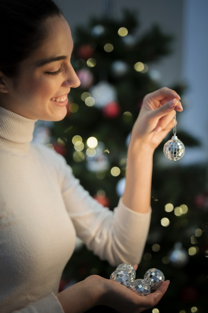 side view,close up,globes,claus,side,indoor,fir,holding,decorations,close,shiny,fir tree,up,portrait,view,young,female,decorative,smiley,gifts,christmas gift,lights,holiday,ornaments,globe,home,santa,woman,gift,santa claus,winter,tree,christmas tree,christmas