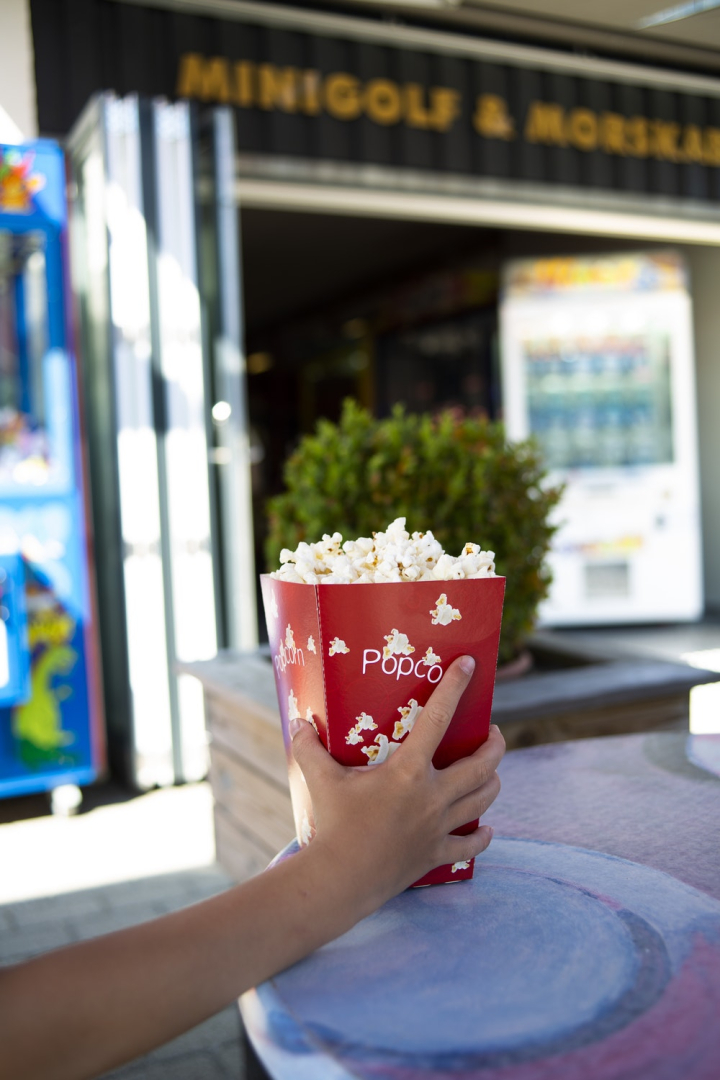blurred background,box,business,cinema,close-up,colors,daylight,delicious,focus,food,food photography,hand,outdoors,person,popcorn,snack,tasty,yummy