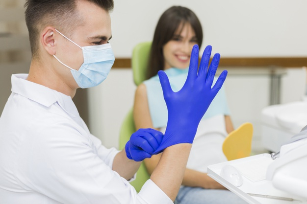 practitioner,orthodontist,surgical gloves,putting,oral hygiene,side view,stomatology,surgical,oral,defocused,side,surgeon,smiling,technician,horizontal,dentistry,hygiene,male,medic,gloves,patient,view,female,dentist,dental,medicine,smile,health,man,woman
