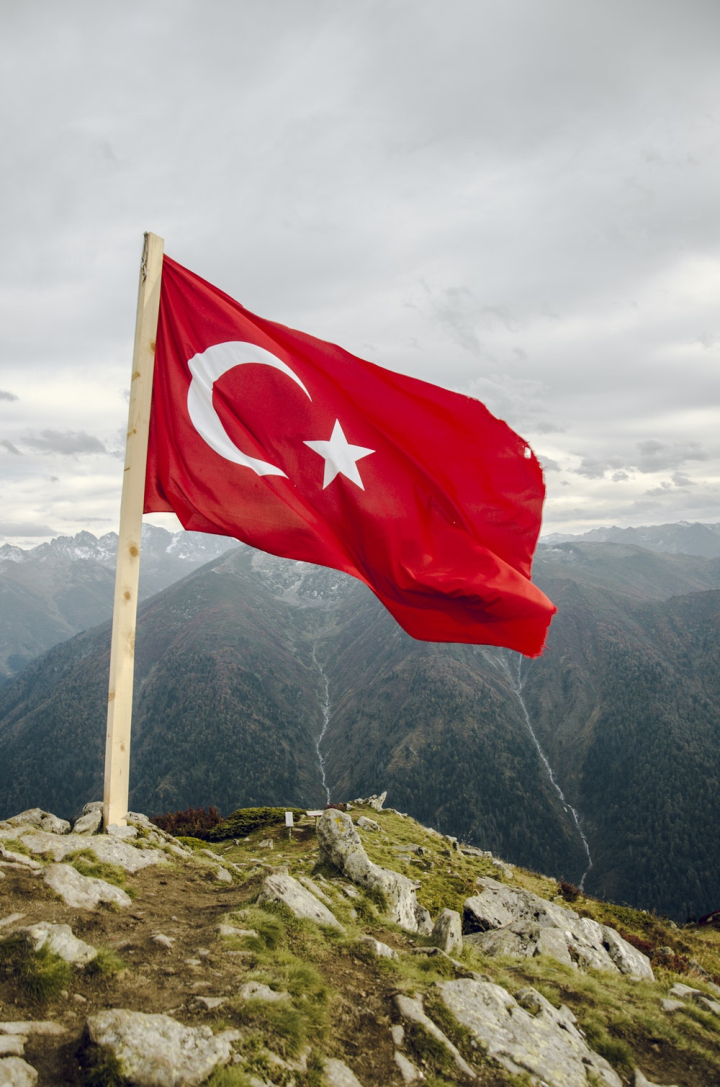 air,breeze,clouds,cloudy,countryside,environment,flag of turkey,flagpole,mountain range,mountains,outdoors,overcast,rural,scenery,sky,turkish flag,wind,windy