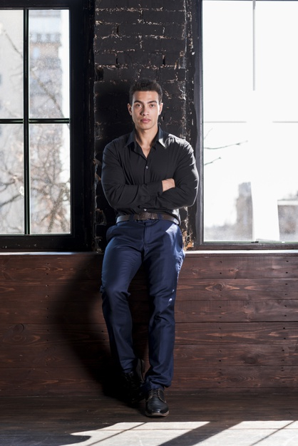 Handsome Asian man leaning on wall stock photo - OFFSET