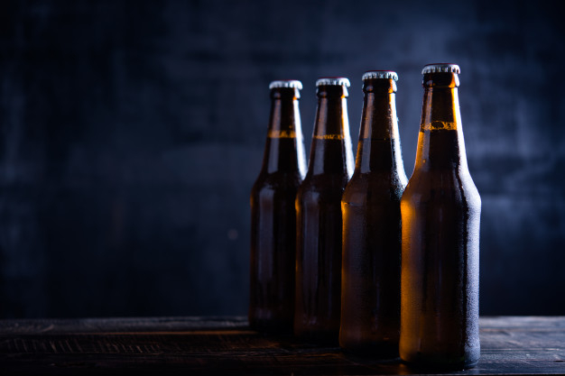 Free Stock Photo of Cold bottles of beer in ice on yellow background