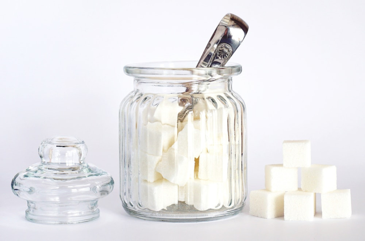 close-up,container,cubes,glass jar,jar,lid,opened,sugar,sugary,sweet,white background