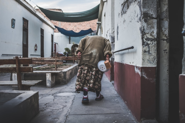 adult,alley,building,concrete,daylight,elderly,exterior,facade,home,houses,old,outdoors,pavement,person,rustic,street,town,travel,urban,wear,woman
