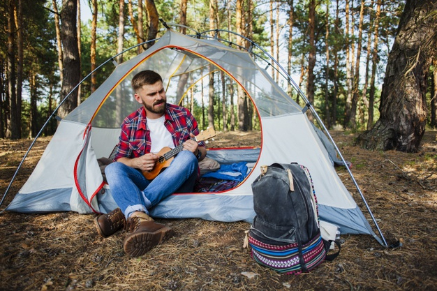 Free: Young man in tent playing quitar Free Photo - nohat.cc