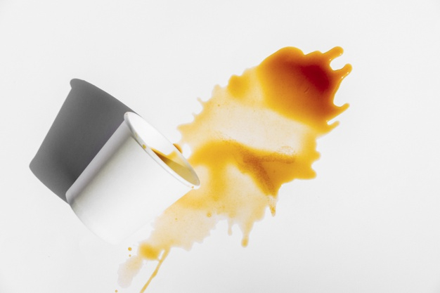 Single Drop Of Coffee Splashing Into A White Cup Mug Close Up View