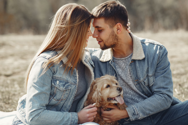 cheerful,boyfriend,casual,handsome,girlfriend,leisure,pretty,fur,adult,romance,relationship,male,lovers,day,portrait,sitting,emotion,jacket,young,together,female,outdoor,jeans,romantic,field,beard,park,makeup,couple,grass,cute,animal,girl,nature,dog,love