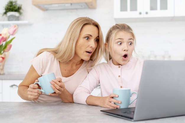 affection,amazed,daughter,blonde,mum,mummy,looking,horizontal,parent,relationship,beautiful,care,mother,laptop,girl,woman,family,love,people