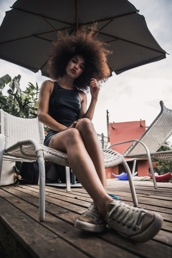 Free: Woman Sitting on Lounger Under Umbrella - nohat.cc