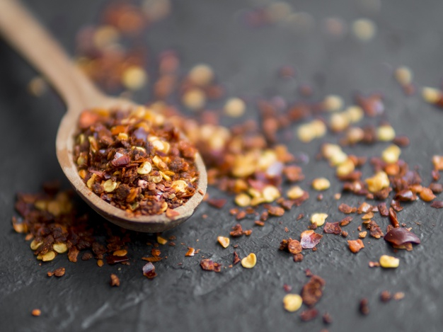 Spices in spoons on black background.