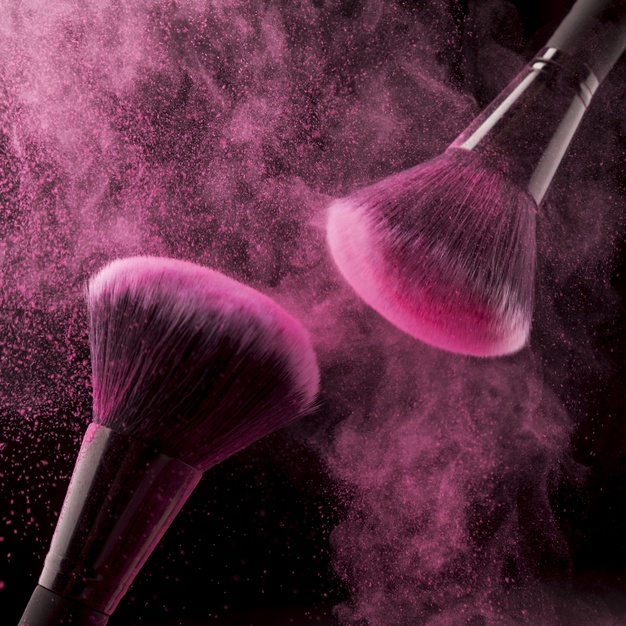 Free: Two cosmetic brushes and pink powder on dark background Free