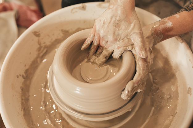 Potter moulding clay on pottery wheel