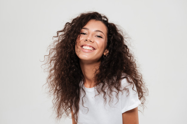haircare,styling,posing,joyful,brunette,attractive,cheerful,perfect,smiling,pretty,laughing,adult,curly,portrait,beautiful,wellness,hairstyle,young,female,youth,healthy,natural,person,happy,face,hair,woman,hand