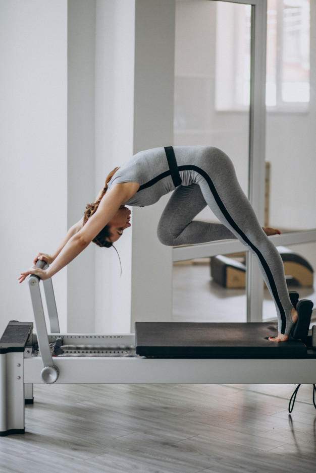 Free: Woman practising pilates in a pilates reformer Free Photo - nohat.cc