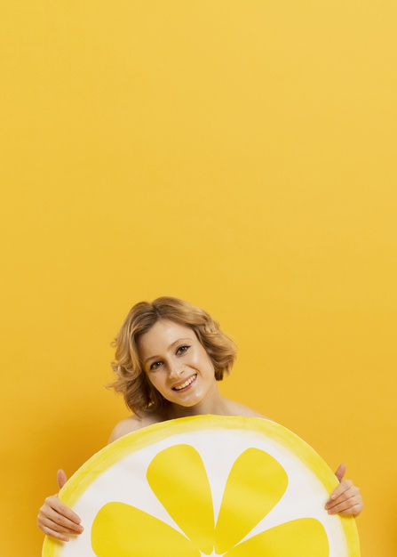 high angle,copy space,lemon slice,slice,high,indoor,vertical,copy,angle,holding,portrait,beautiful,young,female,studio,model,lemon,smiley,yellow,space,woman