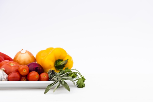 Heap of fresh cut organic vegetables isolated on white background