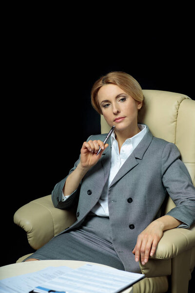 woman,working,formalwear,people,suit,professional,Gesturing,businesswoman,corporate,business,caucasian,occupation,on black,blonde,leader,armchair,documents,person,profession,papers,alone,sitting,copy space,executive,studio,paperwork,thoughtful,pensive,work,european,depositphotos