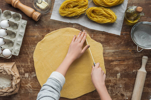 paper,dough,objects,uncooked,person,wood,wooden,natural,cooker,food,Italian cuisine,rolling pin,flour,ingredients,knife,equipment,cut,preparation,fresh,products,rustic,homemade,kitchen,cookery,table,female,recipe,sieve,nutrition,pasta,raw,supplies,grocery,top view,salt mill,background,cook,butter,people,culinary,woman,organic,gastronomy,eggs,oil,utensils,depositphotos