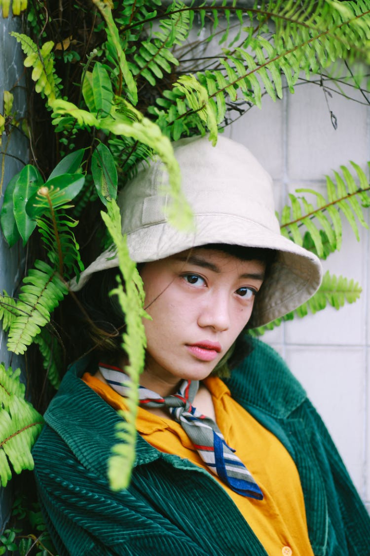 bucket hat,close-up,face,fashion,fern plant,girl,green jacket,neckerchief,portrait,pretty,student,teen,vertical shot